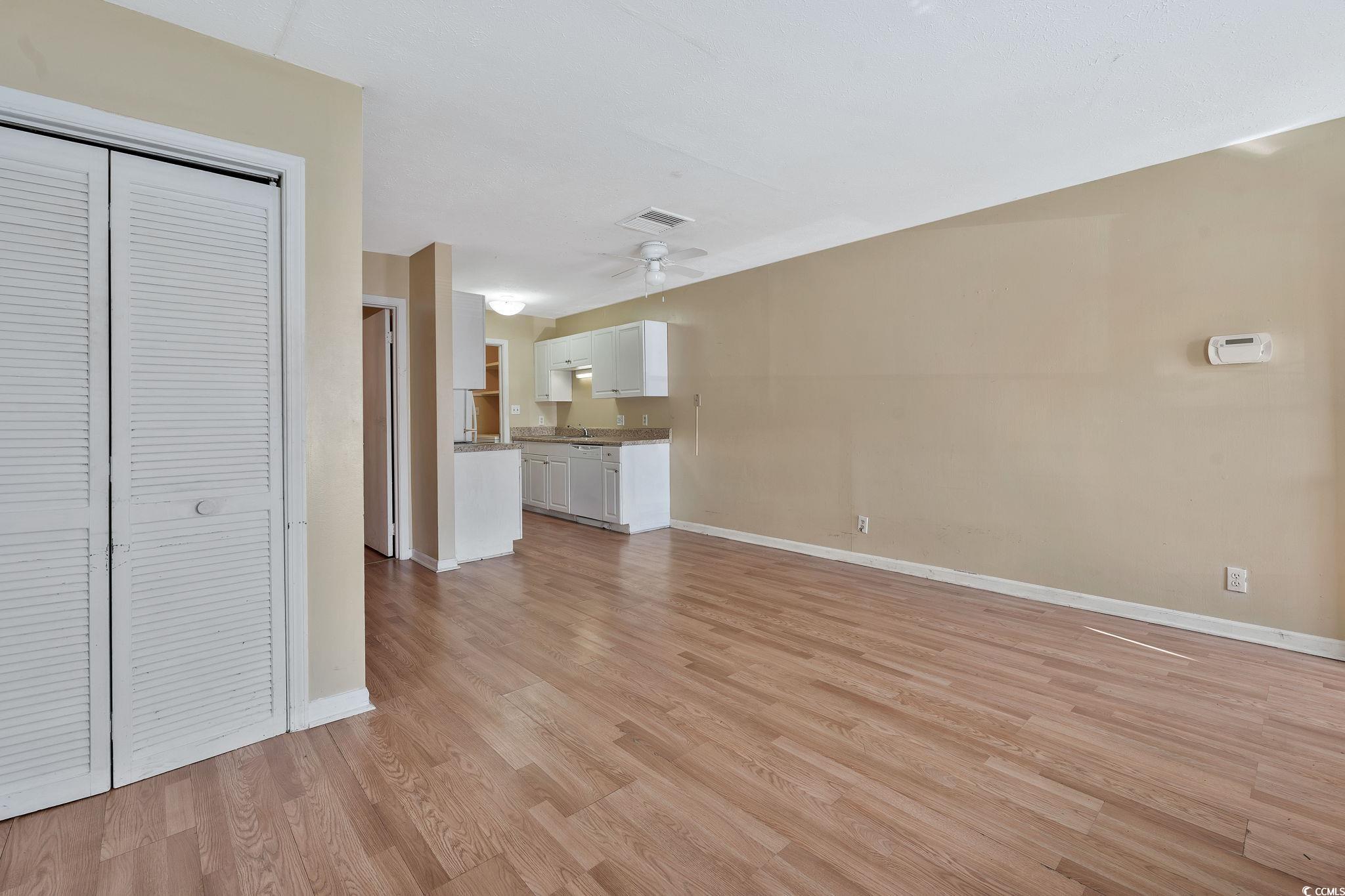 Unfurnished living room featuring ceiling fan and