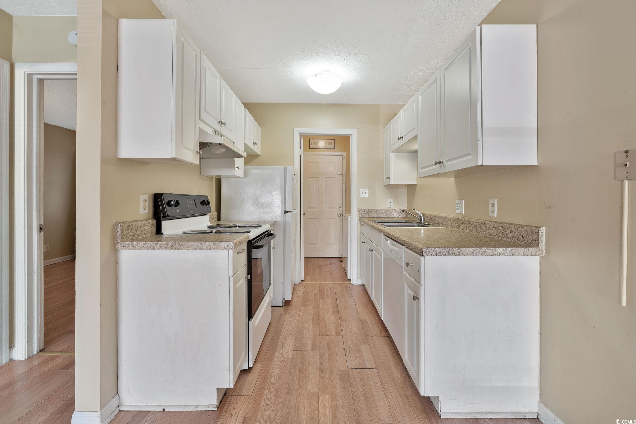 Kitchen with white cabinets, white dishwasher, sin