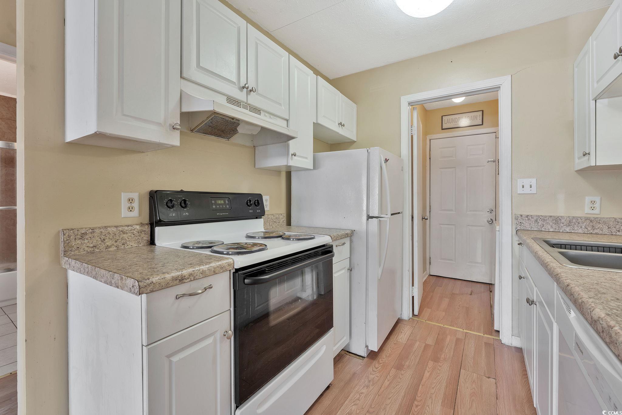 209 Cedar Street, Unit C7 Myrtle Beach, SC 29577 - Photo 8 of 13 Kitchen featuring white cabinetry, sink, light har