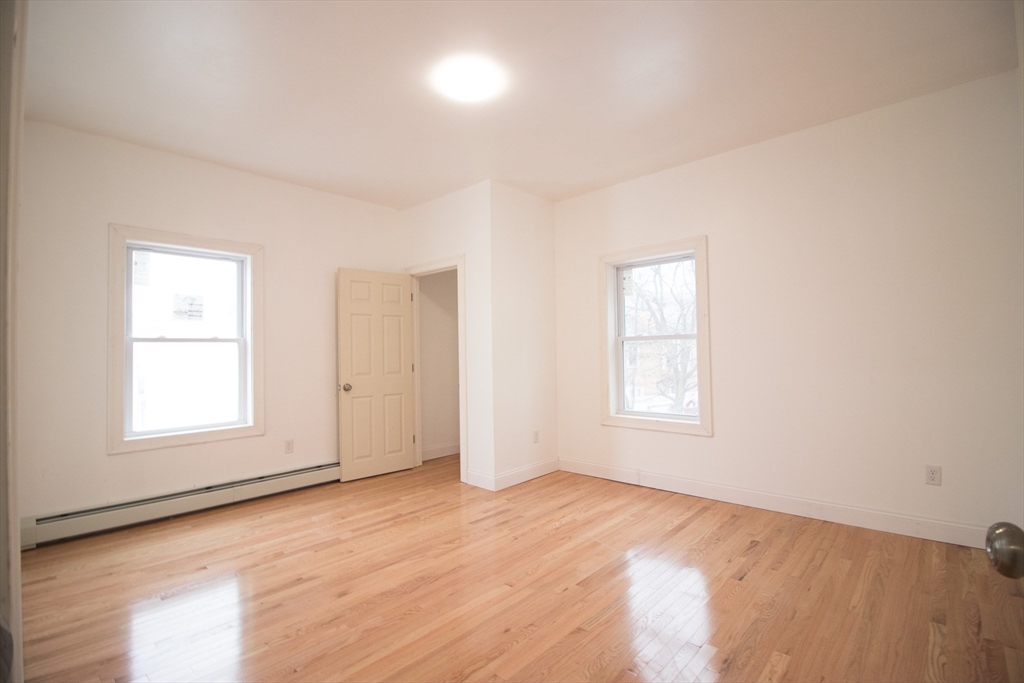 58 Willow Street Lowell, MA 01852 - Photo 11 of 21 an empty room with wooden floor and windows