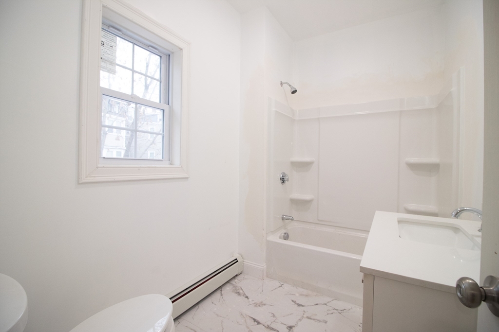 58 Willow Street Lowell, MA 01852 - Photo 18 of 21 a bathroom with a bathtub and toilet