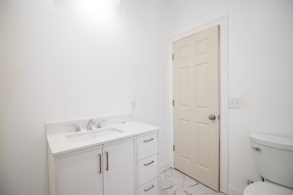 58 Willow Street Lowell, MA 01852 - Photo 19 of 21 a bathroom with a sink a toilet and shower