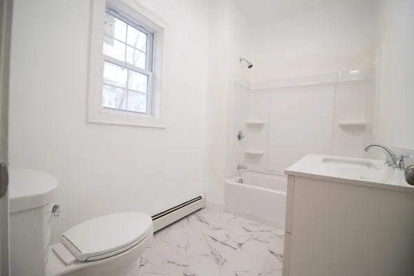 a bathroom with a granite countertop toilet sink and mirror