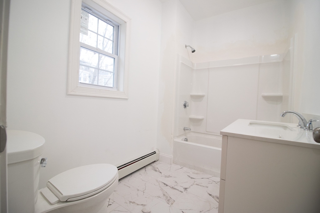 58 Willow Street Lowell, MA 01852 - Photo 21 of 21 a bathroom with a granite countertop toilet sink and mirror