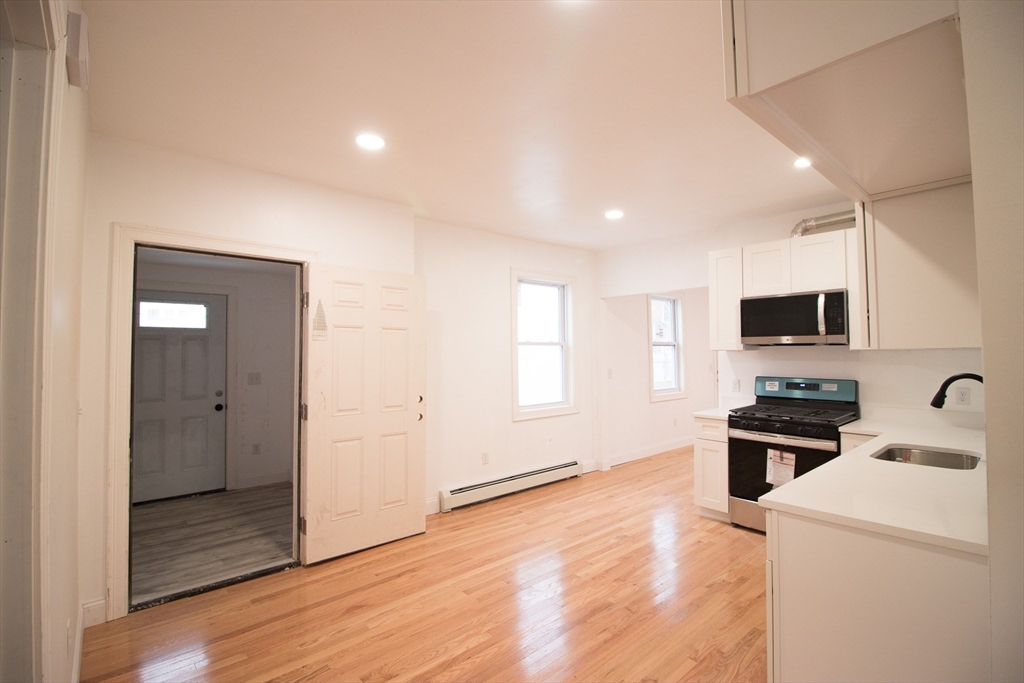 58 Willow Street Lowell, MA 01852 - Photo 3 of 21 a view of a kitchen and a sink dishwasher and wooden floor