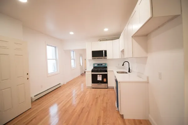 a kitchen with a sink a counter top space stainless steel appliances and a window