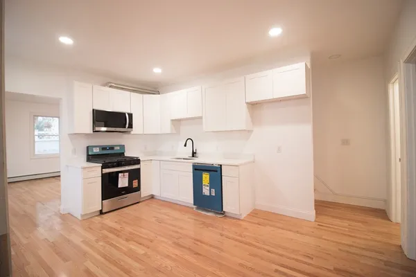 a kitchen with stainless steel appliances granite countertop a stove a sink and a microwave