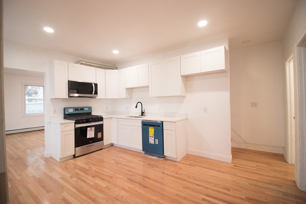 58 Willow Street Lowell, MA 01852 - Photo 5 of 21 a kitchen with stainless steel appliances granite countertop a stove a sink and a microwave