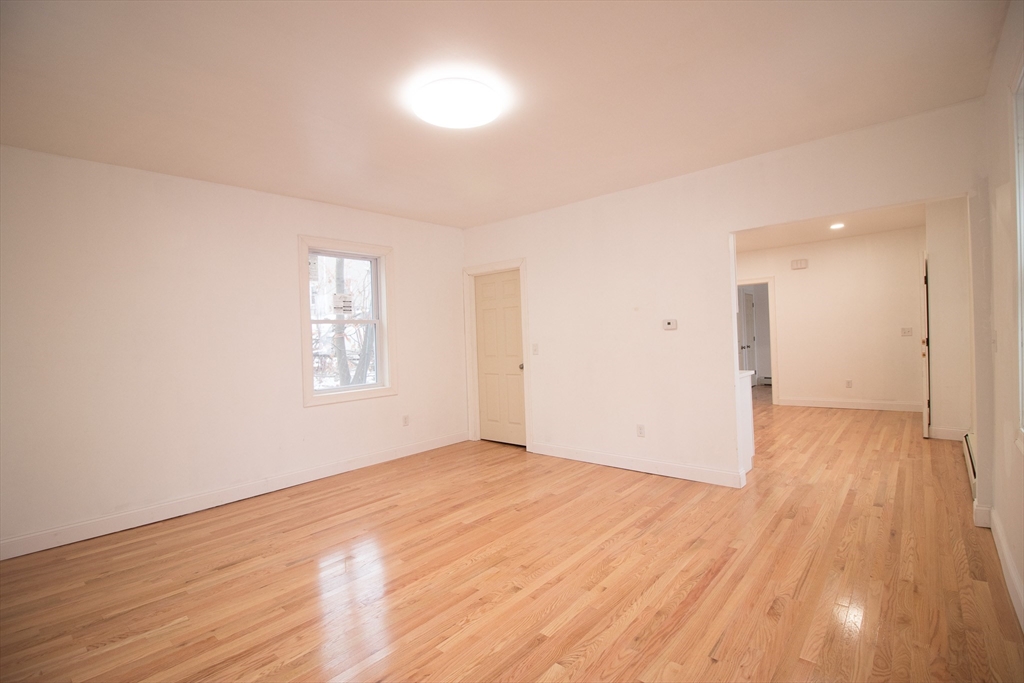 58 Willow Street Lowell, MA 01852 - Photo 6 of 21 an empty room with wooden floor and windows