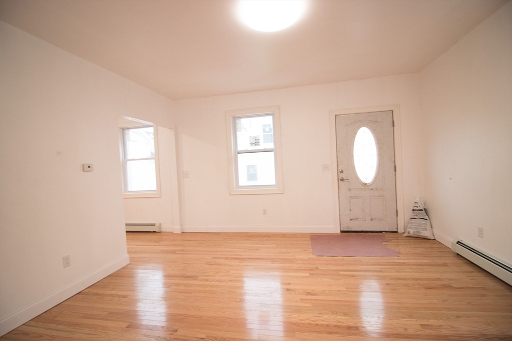58 Willow Street Lowell, MA 01852 - Photo 7 of 21 an empty room with wooden floor and windows
