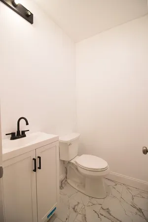 a bathroom with a toilet a sink and mirror