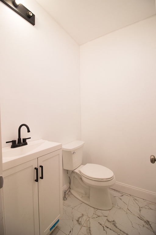 58 Willow Street Lowell, MA 01852 - Photo 8 of 21 a bathroom with a toilet a sink and mirror