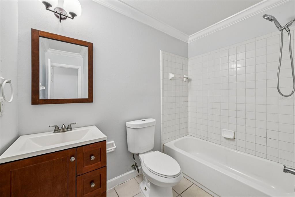 926 Lake Destiny Road, Unit F Altamonte Springs, FL 32714 - Photo 16 of 20 a bathroom with a toilet a sink a mirror a bathtub and shower