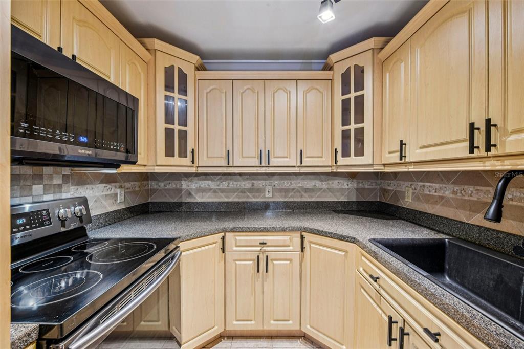 926 Lake Destiny Road, Unit F Altamonte Springs, FL 32714 - Photo 9 of 20 a kitchen with granite countertop a stove sink and cabinets