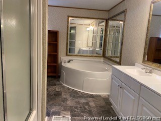 108 McIver Road Raeford, NC 28376 - Photo 22 of 40 a bathroom with a tub a sink and a large mirror