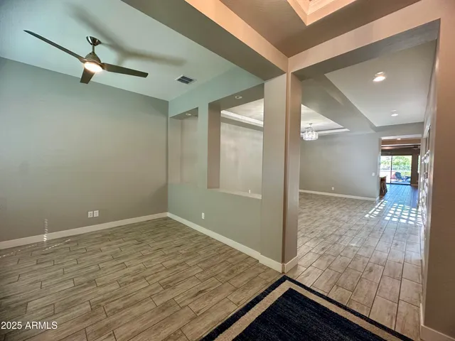an empty room with wooden floor and mirror