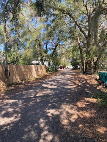 a view of a yard with wooden fence
