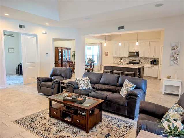 a kitchen with stainless steel appliances granite countertop a table chairs microwave and sink