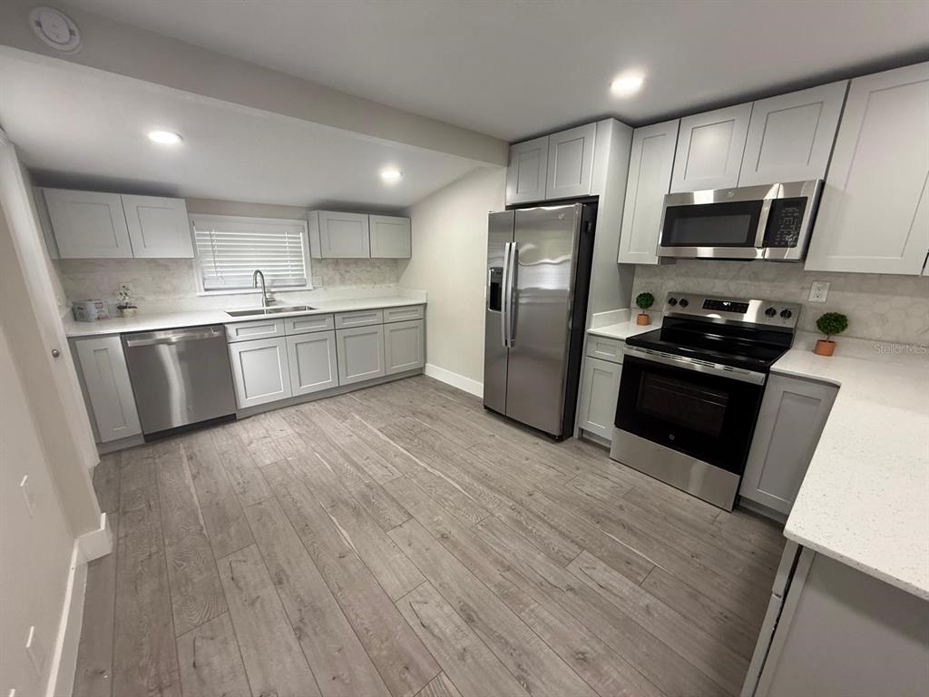 721 Magnolia Street Windermere, FL 34786 - Photo 8 of 13 a kitchen with stainless steel appliances a refrigerator a sink a stove top oven a refrigerator and dishwasher