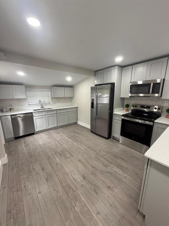 721 Magnolia Street Windermere, FL 34786 - Photo 9 of 13 a kitchen with stainless steel appliances a refrigerator and a stove top oven