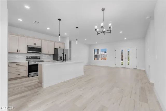 a view of a big room with wooden floor and windows