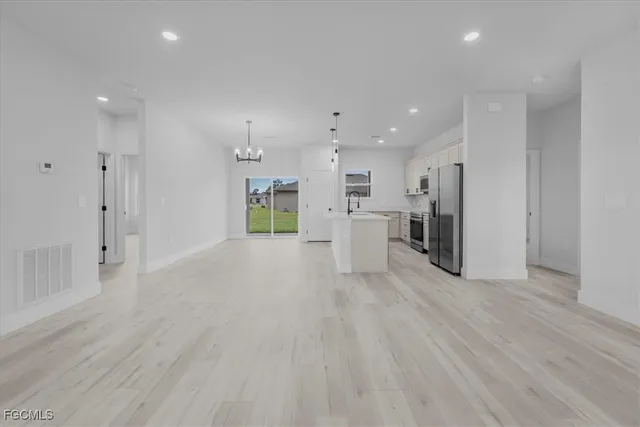 a view of an empty room with a kitchen