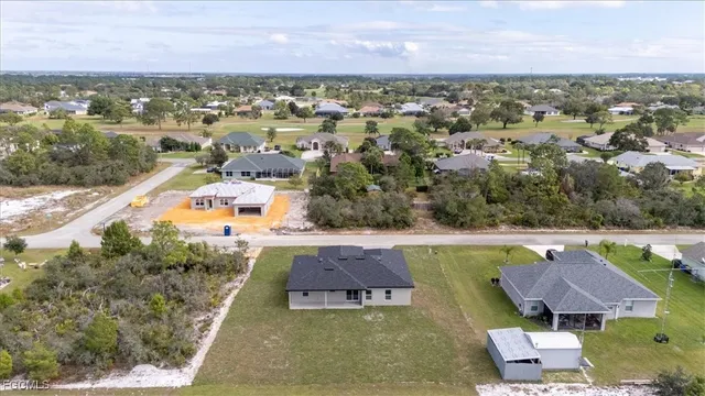 an aerial view of residential houses with outdoor space and lake view