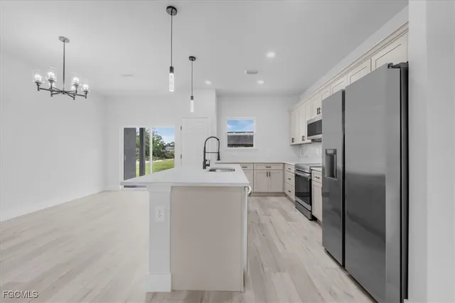a kitchen with kitchen island a sink stainless steel appliances and cabinets