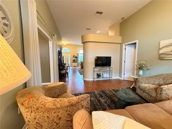 a view of a livingroom with furniture mirror and wooden floor