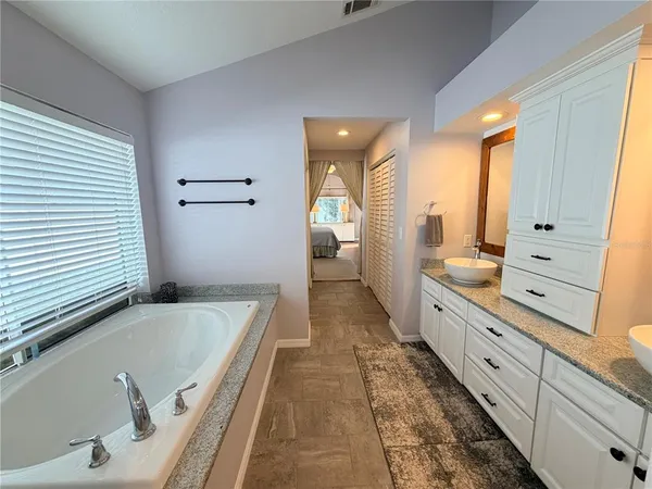 a bathroom with a tub sink and mirror