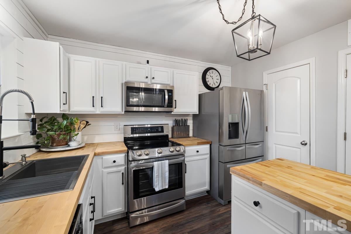 1205 Lombar Street Raleigh, NC 27610 - Photo 11 of 31 a kitchen with stainless steel appliances granite countertop a stove a sink and a refrigerator