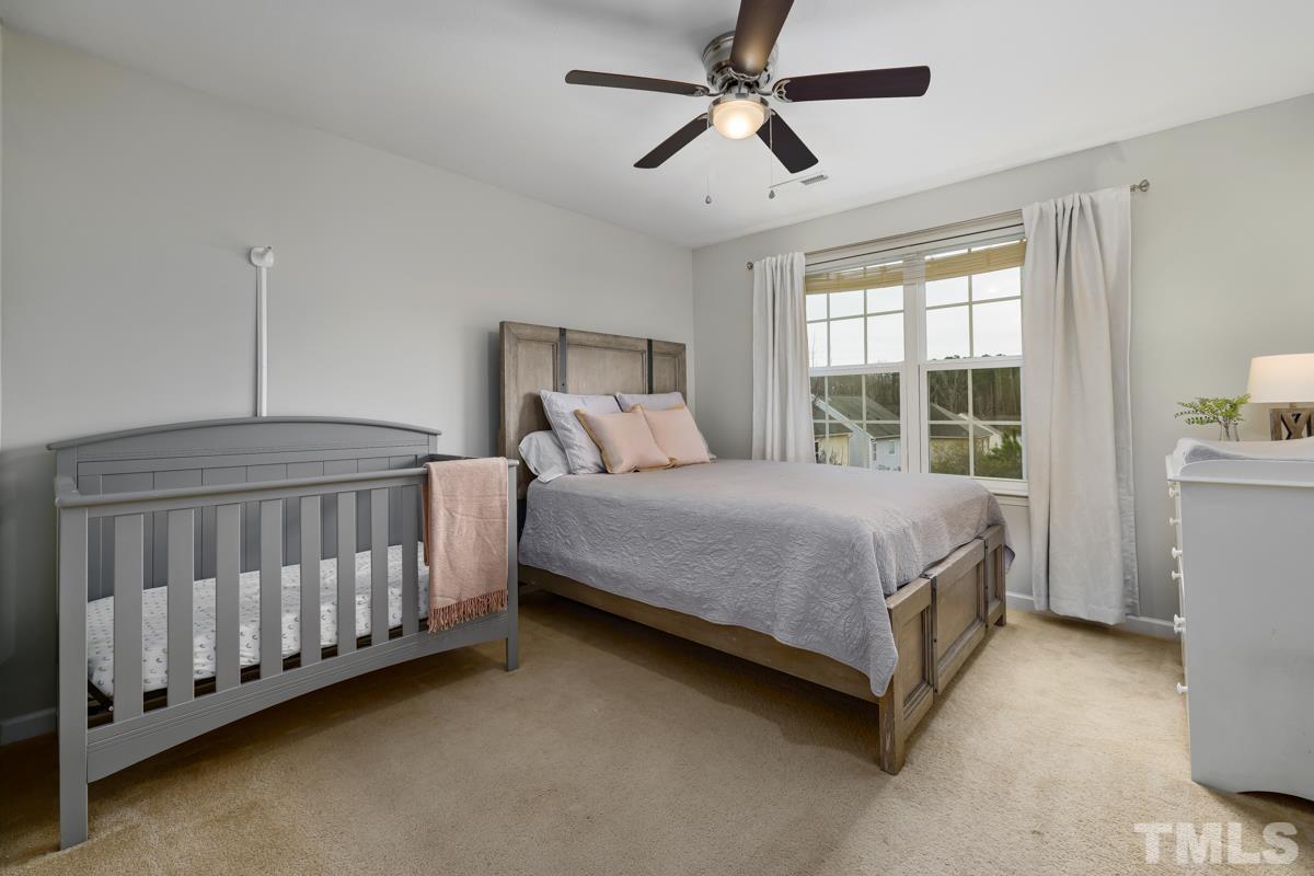 1205 Lombar Street Raleigh, NC 27610 - Photo 23 of 31 a bedroom with a bed chandelier and a window