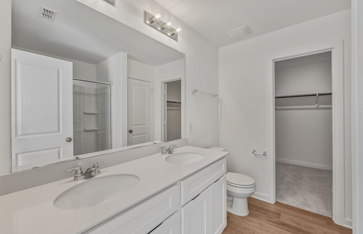 172 Golden Bell Way Buda, TX 78610 - Photo 11 of 24 a bathroom with a granite countertop sink a toilet and shower