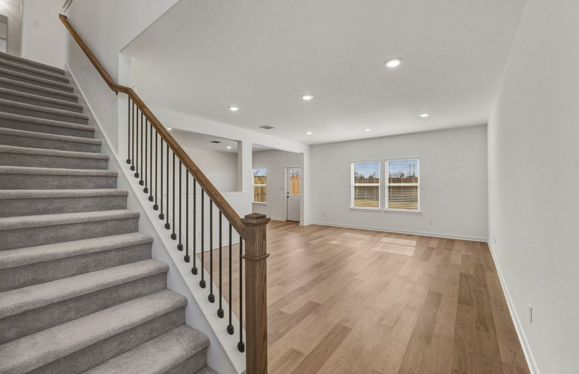 172 Golden Bell Way Buda, TX 78610 - Photo 3 of 24 a view of an empty room with wooden floor and stairs
