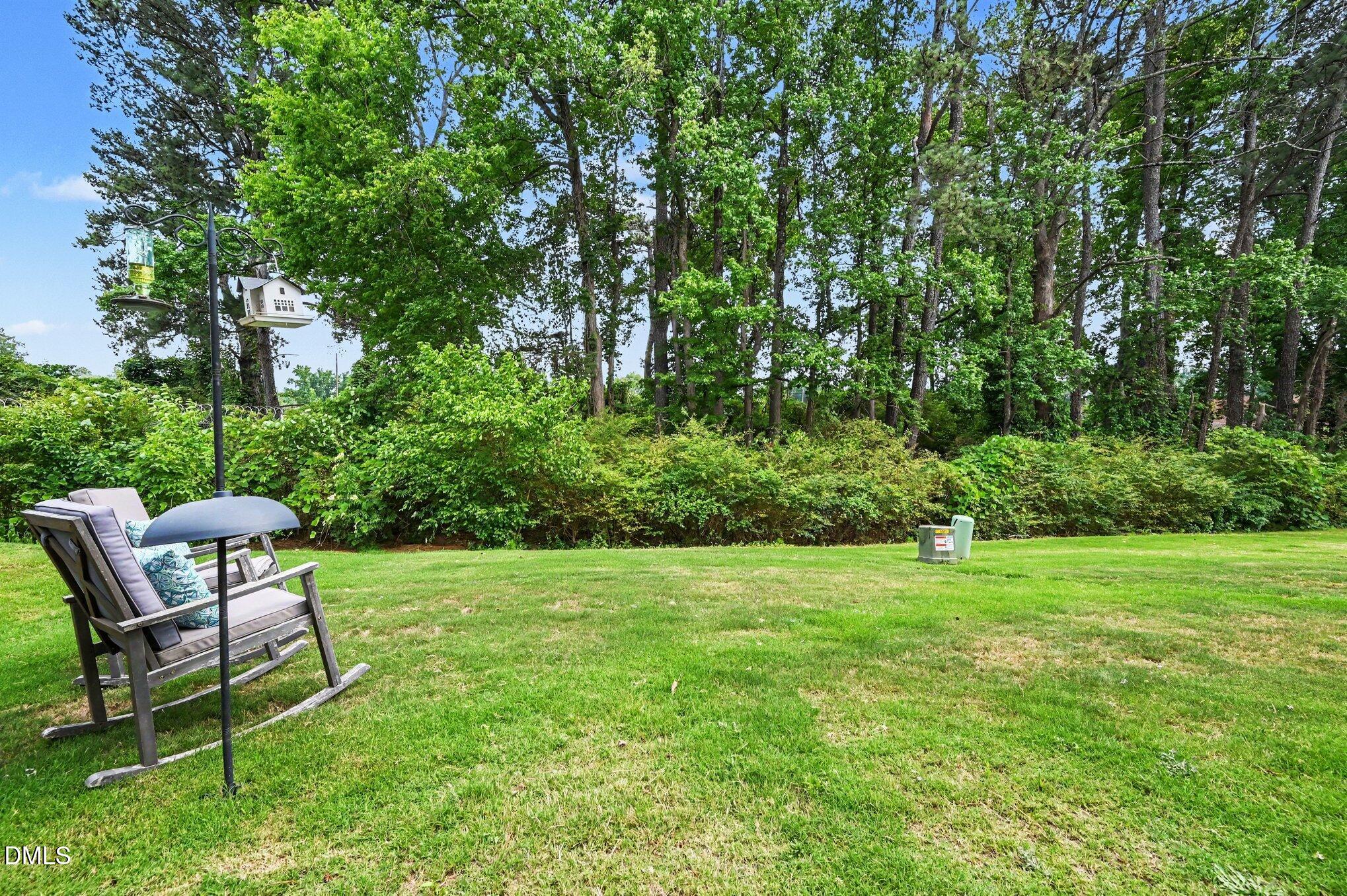 574 Hacksaw Trail Raleigh, NC 27610 - Photo 23 of 28 a view of a backyard with table and chairs and potted plants and large trees