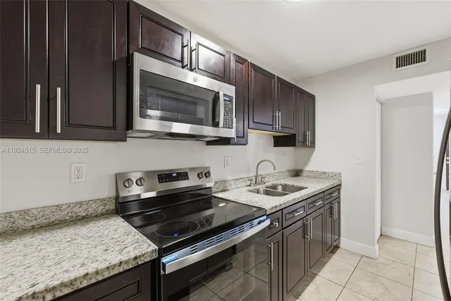 a kitchen with stainless steel appliances granite countertop a stove microwave and cabinets