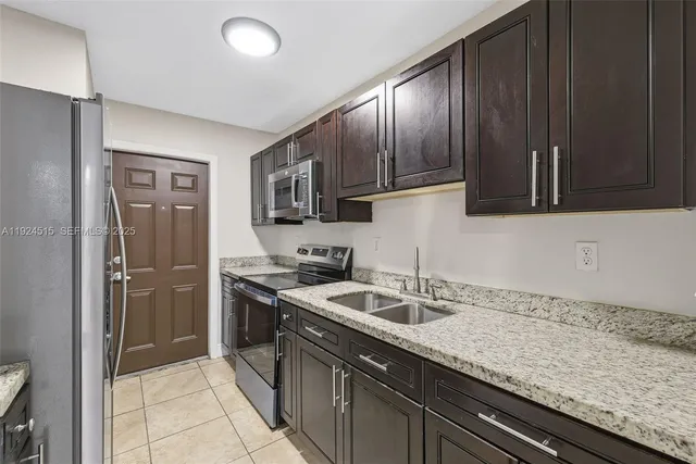 a kitchen with granite countertop stainless steel appliances a sink and cabinets