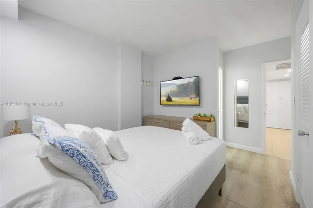 a bed room with a bed and a painting on the wall