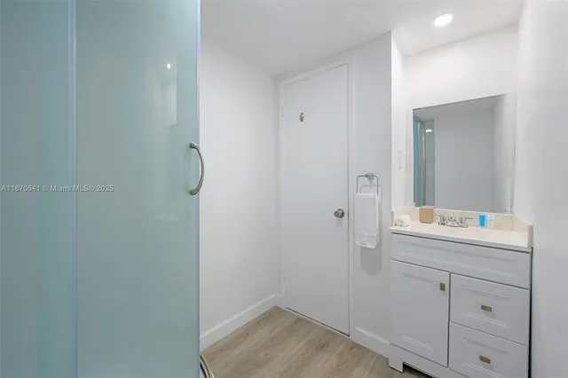 a bathroom with a shower sink and mirror