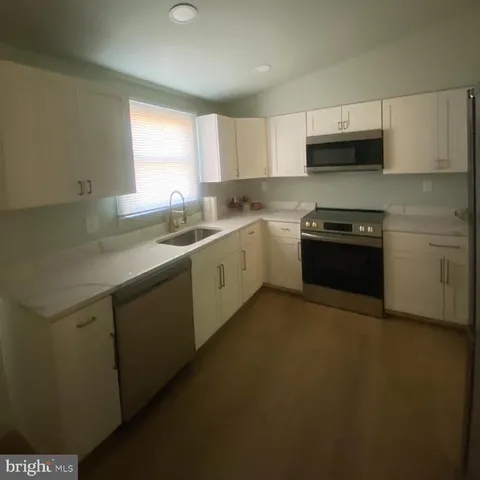 a kitchen with stainless steel appliances granite countertop a sink stove and microwave