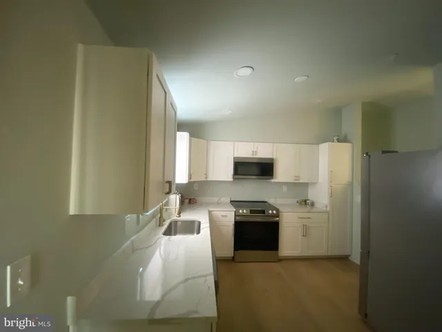 a kitchen with stainless steel appliances granite countertop a stove a sink and a refrigerator