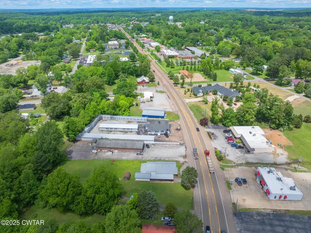an aerial view of residential houses with outdoor space and trees
