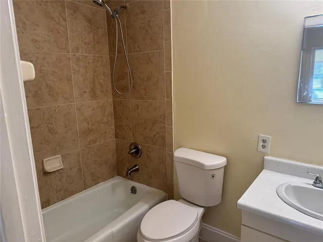 a white toilet and shower sitting next to a bathroom sink