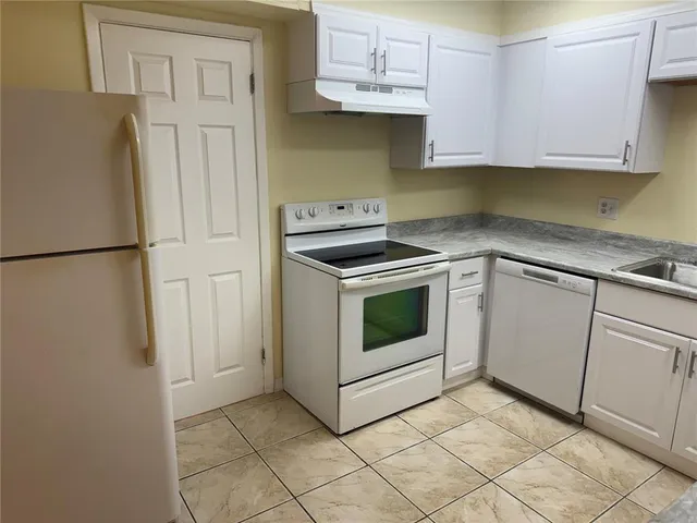 a kitchen with white cabinets and white appliances