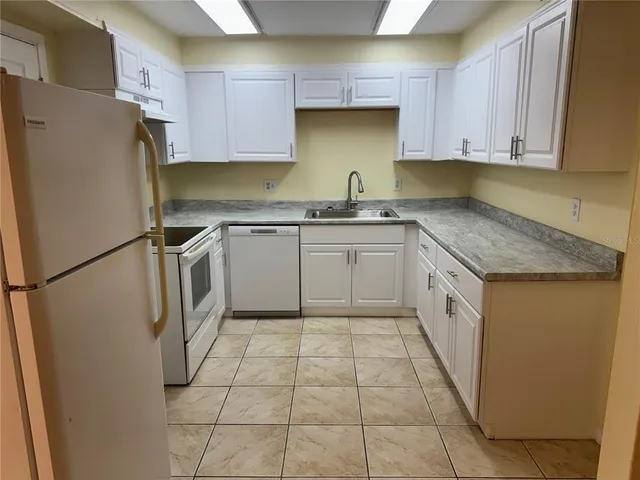 a kitchen with stainless steel appliances granite countertop a refrigerator sink and cabinets
