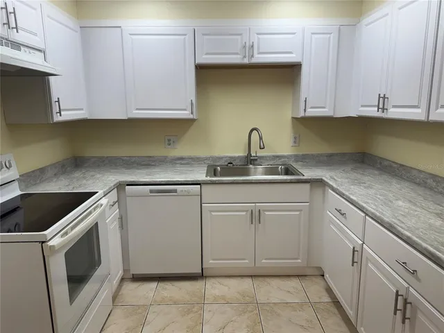 a kitchen with stainless steel appliances granite countertop a sink and a stove