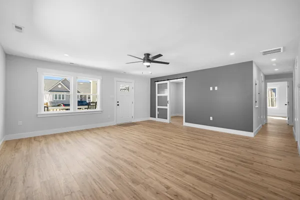 a view of a livingroom with furniture wooden floor and a ceiling fan