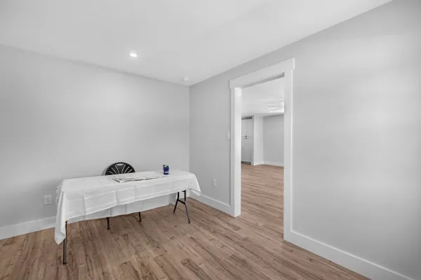 a kitchen with stainless steel appliances a dining table chairs and wooden floor