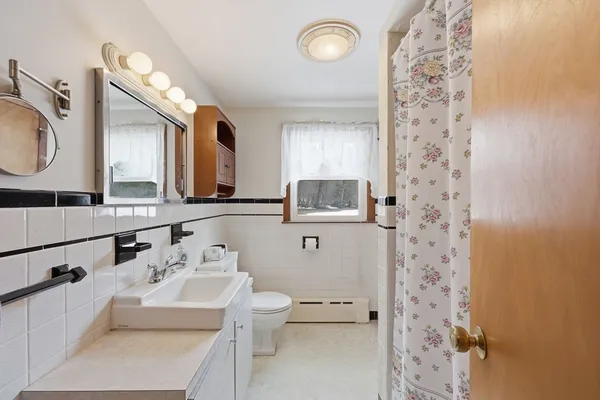 a bathroom with a sink mirror vanity and toilet