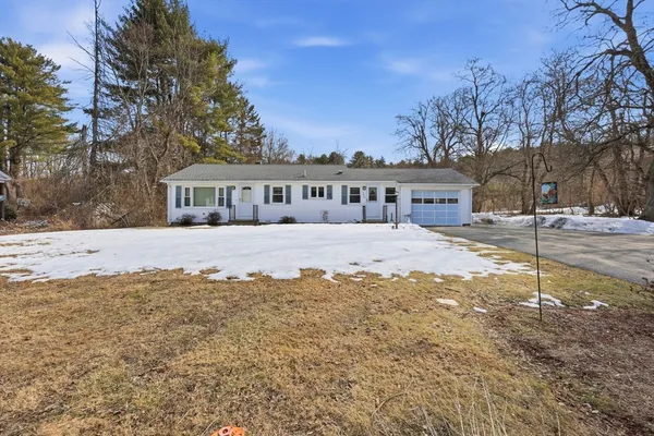 a view of large house with a yard covered in snow